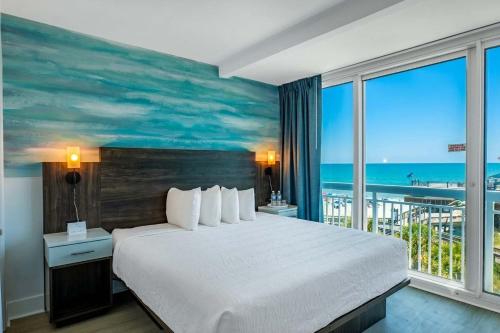 a bedroom with a large bed with a view of the ocean at Coastal Modern Oceanfront 2BR Yachtsman S506 in Myrtle Beach