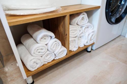 a pile of towels on a shelf next to a washing machine at Villa Merak House in Bijelo Brdo