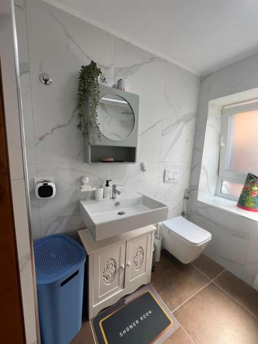 a white bathroom with a sink and a toilet at Vila 4 Stinet in Pogradec