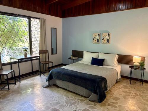 a bedroom with a bed and a large window at casa luca in San José