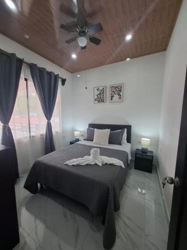 a bedroom with a bed and a ceiling fan at Paradise 1 in Jacó