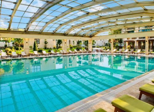 a large swimming pool with a glass ceiling at Boutique 1BR | Long Beach Sea View Next to the Beach in Shkorpilovtsi