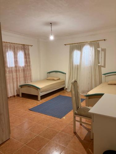 a room with two beds and a chair in it at Villa agamy in Burj al ‘Arab al Jadīdah