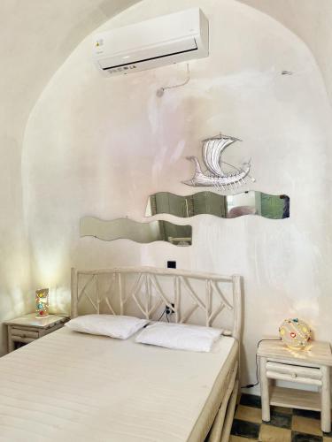 a bedroom with a bed and a white wall at Argonaut House in Anafi