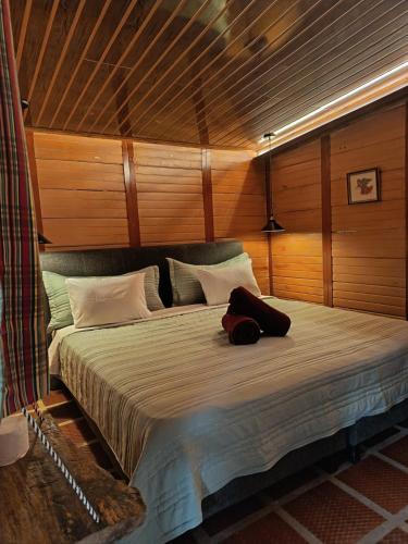 a large bed in a room with wooden walls at Altos de Shalem casa canaan in Anolaima