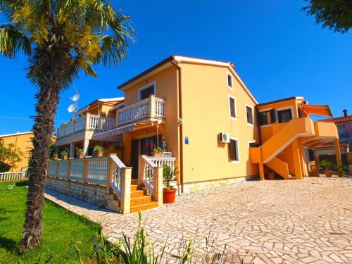 ein Haus mit einer Palme davor in der Unterkunft Apartments Orange 768 in Fažana