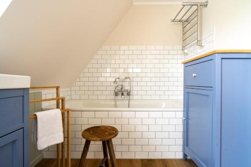 a bathroom with a bath tub and a stool at Ferienhaus WalnutCottage in Rechlin