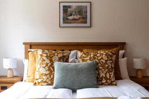 a bed with pillows and a picture on the wall at Ferienhaus WalnutCottage in Rechlin