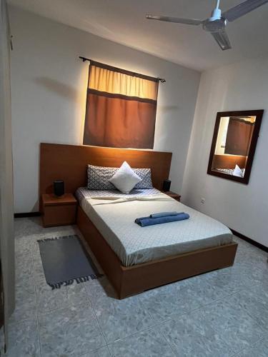 a bedroom with a bed with a headboard and a mirror at Isa House - Private Rooms in a Shared Duplex in Praia