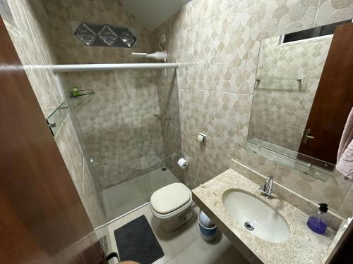 a bathroom with a toilet and a sink and a shower at Chico de Sá Pousada in Pirenópolis