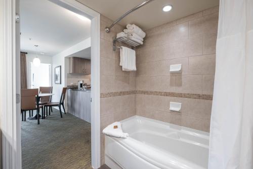 a bathroom with a bath tub and a kitchen at Executive Suites Hotel and Resort, Squamish in Squamish