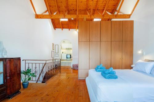 a bedroom with a large white bed and a staircase at Kooreloo Airy Loft in Koroni