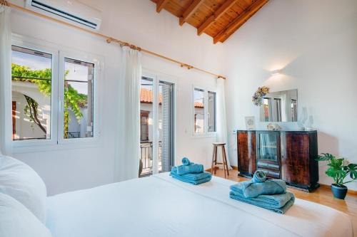 a white bedroom with a large bed and windows at Kooreloo Airy Loft in Koroni