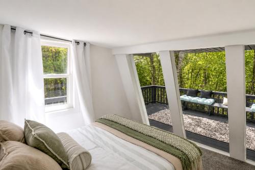 a bedroom with a bed and a large window at High-Design Monroe Cabin on 2 Private Acres! in Readsboro