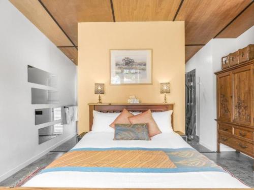 a bedroom with a large bed with a wooden headboard at Lianna Bungalow in Auburn