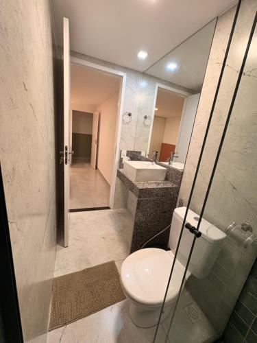 a bathroom with a toilet and a sink and a mirror at Oásis urbano in Muriaé