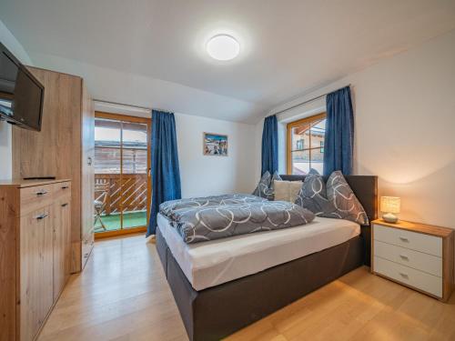 ein Schlafzimmer mit einem großen Bett und blauen Vorhängen in der Unterkunft Summa Haisl in Embach