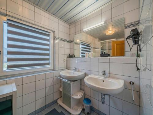 ein Badezimmer mit Waschbecken, Toilette und Spiegel in der Unterkunft Summa Haisl in Embach