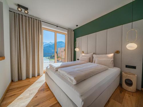 a bedroom with a large bed and a large window at Premium XL in Hollersbach im Pinzgau