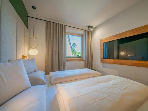 a hotel room with two beds and a flat screen tv at Premium Apartment Almrausch in Hollersbach im Pinzgau