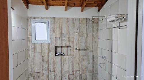 a bathroom with a shower with a window at Cabañas Altos del Sauce in Villa General Belgrano