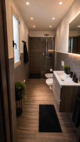 a bathroom with two toilets and a sink and a mirror at LoFT in Bosa