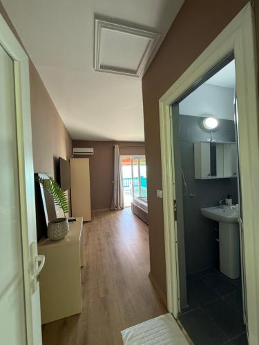 a room with a hallway with a sink and a mirror at Yamas Hotel "Ex Malibu" in Dhërmi