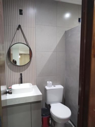 a bathroom with a toilet and a sink and a mirror at Pousada Ferreira TJ - AP 02 in Cesário Lange