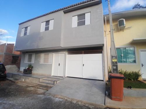 a white house with four garage doors on it at Pousada Ferreira TJ - AP 02 in Cesário Lange