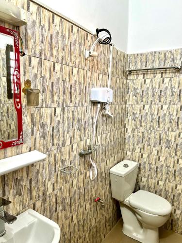 a shower in a bathroom with a toilet and a sink at Résidence Saphir-Korhogo in Korhogo
