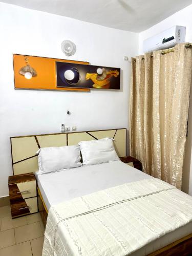 a bedroom with two beds and a tv on the wall at Résidence Saphir-Korhogo in Korhogo