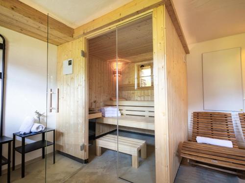 a bathroom with a bench and a glass shower at Tirola Hütte in Alpbach