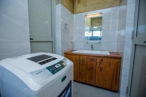 a small bathroom with a sink and a washing machine at Lovina Heights in Mount Lavinia