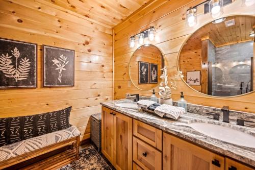 a log cabin bathroom with a sink and a mirror at Top Rated Modern 3BD |Secluded |Fire Pit |Arcade in Sevierville