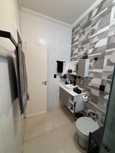 a bathroom with a toilet and a sink at Sussurros do Mar in Bertioga