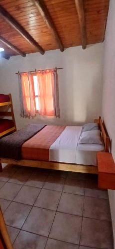 a wooden bed in a room with a window at Cabañas fenix alojamiento in San Rafael