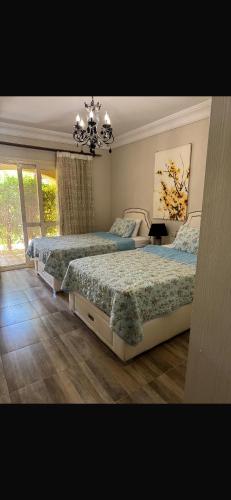 a bedroom with two beds and a chandelier at Lavista 7 in Ain Sokhna