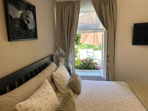a bedroom with a bed with pillows and a window at Bedroom with extension on Veranda in Yvoir