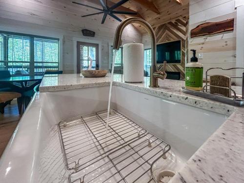 a kitchen with a dish rack on a counter at Hot Tub Cabin + Screened Porch | Red River Gorge in Beattyville