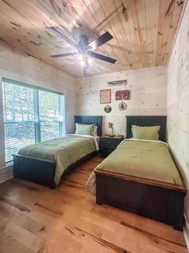 a bedroom with two beds and a ceiling fan at Hot Tub Cabin + Screened Porch | Red River Gorge in Beattyville