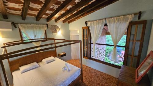 a bedroom with a bunk bed and a window at Hotel Casa Huijazoo in Mazunte
