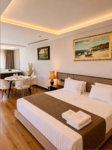 a hotel room with a bed and a dining room at Joelle Premium Hotel in Sarandë
