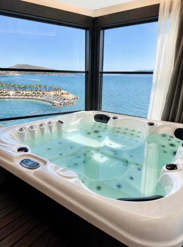 a hot tub in a room with a view of the ocean at Joelle Premium Hotel in Sarandë