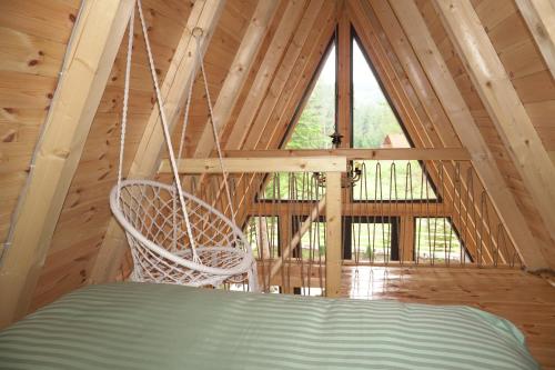 a swing in a cabin with a large window at Ninas Villas in Vrela