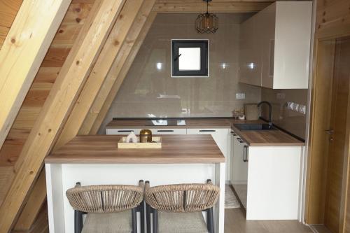 an attic kitchen with a counter and two chairs at Ninas Villas in Vrela