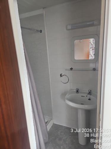 a small bathroom with a sink and a mirror at The Chorlton by Cherish Lewis Hotel in Blackpool