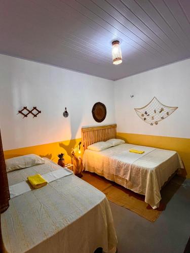 a bedroom with two beds and a light on the ceiling at Casa Amarílis - próxima a Atins in Barreirinhas