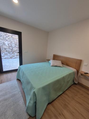 a bedroom with a bed and a large window at Casa da Mexieira em Ponte da Barca in Ponte da Barca