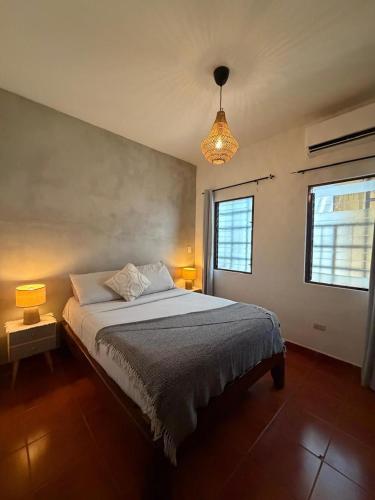 a bedroom with a bed and two lamps and a window at Apartamentos El Labrador in Tamarindo
