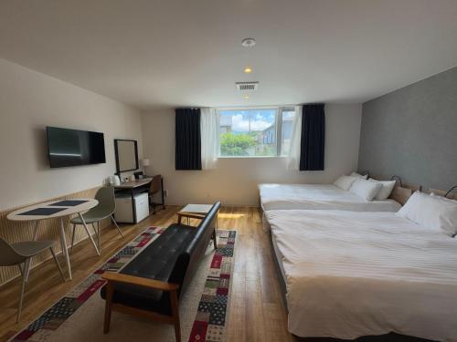 a hotel room with two beds and a table at Megu Fuji 2021 in Fujiyoshida